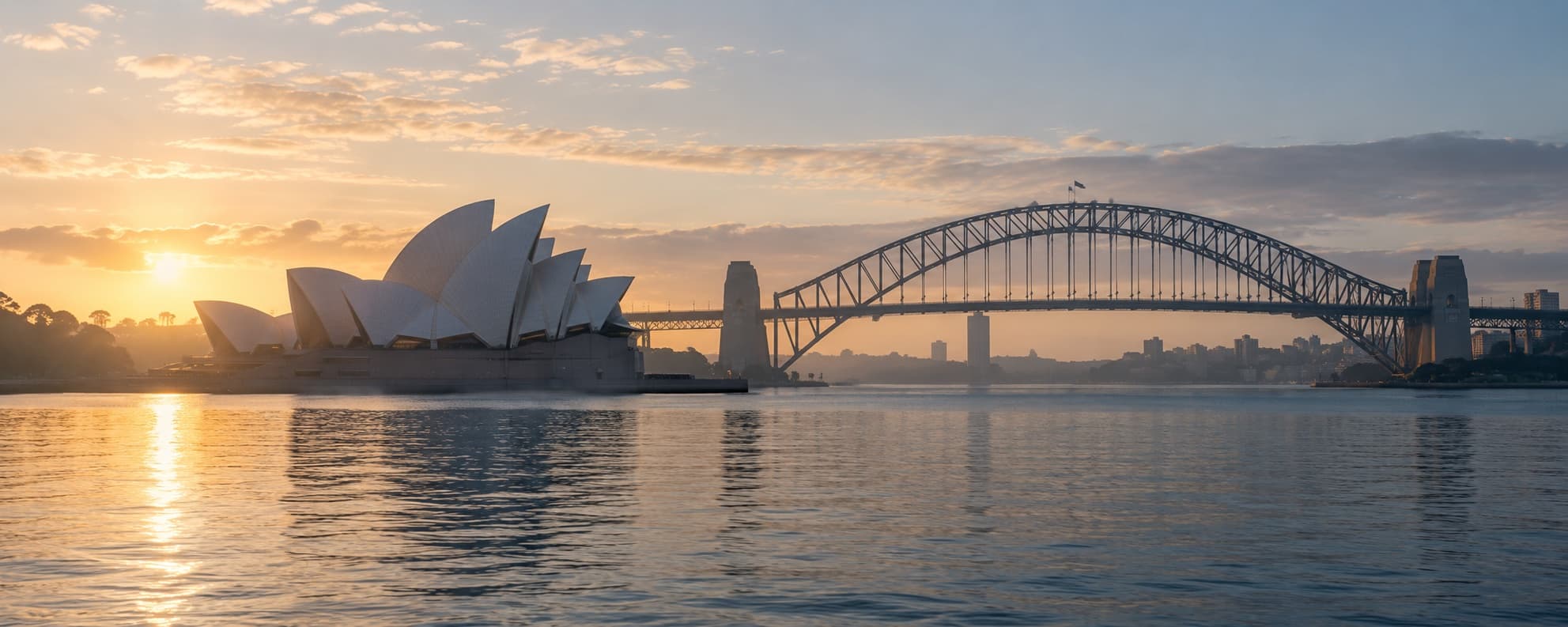 Representative editorial view of the Sydney Opera House and Harbour Bridge in warm morning light